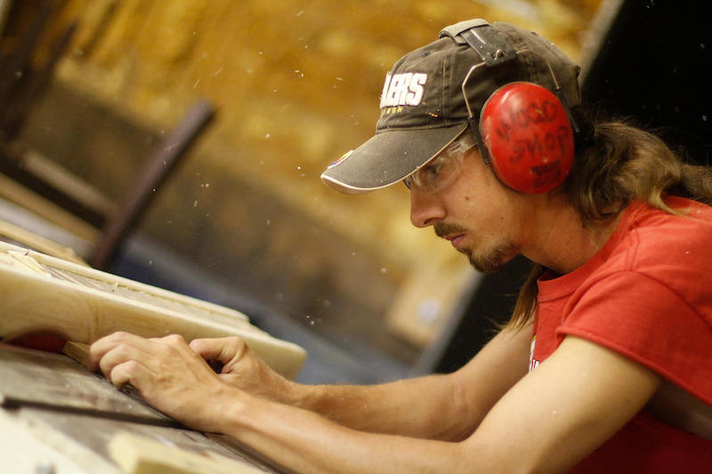 Teenage boy working in a wood shop.